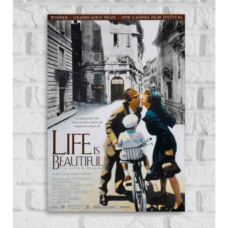 Poster of the film 'Life Is Beautiful' (La Vita è Bella), showing a heartwarming scene where a man kisses a woman while a young boy, presumably their son, sits on a bicycle between them. The background features a vintage European street in black and white, while the characters are in color, highlighting their emotional connection. The title 'Life Is Beautiful' is prominently displayed at the bottom with the tagline 'An unforgettable fable that proves love, family and imagination conquer all.'