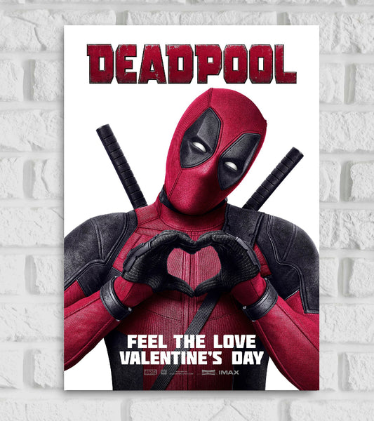 Poster for the Marvel film "Deadpool" The image features Deadpool in his iconic red and black suit, striking a playful pose with his gloved hands forming a heart shape over his chest Two swords are strapped to his back The background is plain white, making the character stand out prominently the title “DEADPOOL” is written metallic-textured letters. Below, the tagline reads “FEEL THE LOVE VALENTINE’S DAY” Cute Avengers Hollywood Actor based on the Marvel Comics Ryan Reynolds 