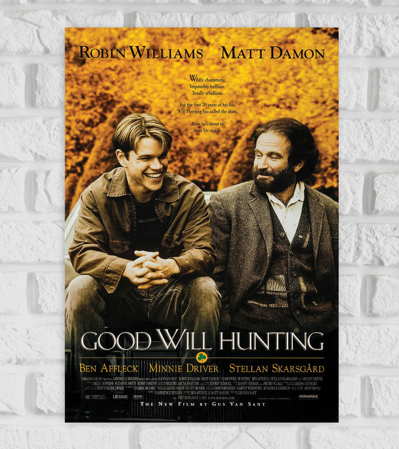 Poster for the film "Good Will Hunting" featuring Robin Williams and Matt Damon. The image shows the two characters sitting side by side on a bench, with Matt Damon smiling brightly and Robin Williams looking at him with a gentle, thoughtful expression. The background is a warm, autumnal yellow with leaves, creating an emotional and nostalgic atmosphere. The title "Good Will Hunting" is written at the bottom in elegant white text with a small clover symbol Hollywood American drama Action
