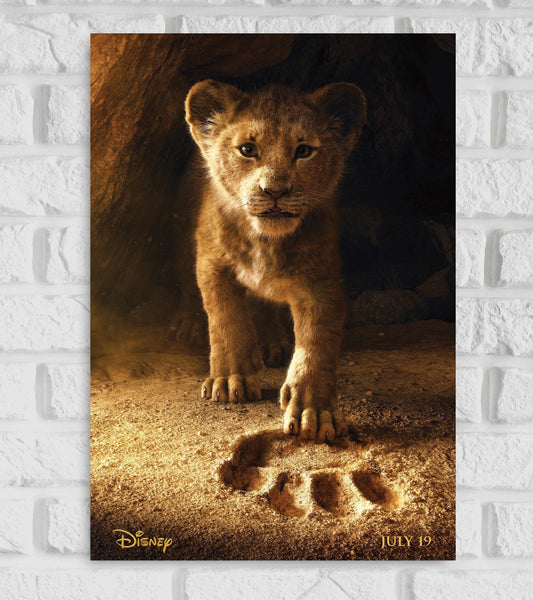 Poster of The Lion King featuring a realistic CGI image of young Simba stepping forward in a cave, placing his paw into a large lion paw print embedded in the sand. The background is dimly lit, creating a dramatic and emotional tone. At the bottom, the Disney logo appears on the left and the release date “JULY 19” is on the right. Hollywood Movies  American animated musical coming-of-age drama film