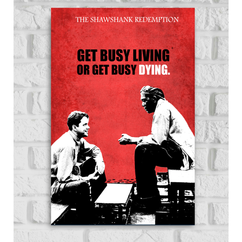 Poster of the movie 'The Shawshank Redemption' featuring a stylized black and white image of two men, Andy Dufresne and Ellis 'Red' Redding, sitting and talking across a chessboard. The background is textured red. At the top, the movie title 'The Shawshank Redemption' is written in white. In the center, a bold quote reads: 'GET BUSY LIVING OR GET BUSY DYING,' with the words 'LIVING' and 'DYING' highlighted in black and white respectively
